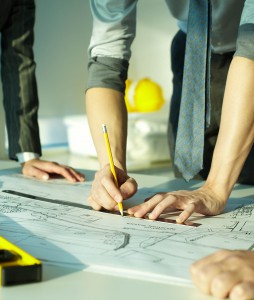 Architects at work Three pairs of hands sketching a housing project
